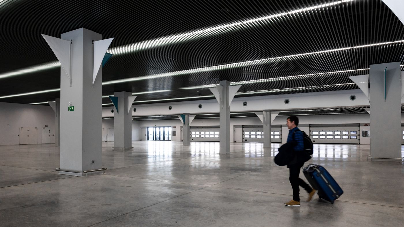 Traveller crossing a modern airport terminal with luggage